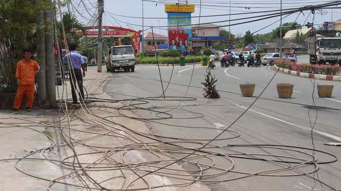 Trưa 14/4, dây điện vẫn vương đầy mặt quốc lộ 13 khiến một hướng lưu thông qua đây bị tắc nghẽn, xe cộ phải đi ngược chiều - Ảnh: Bá Sơn