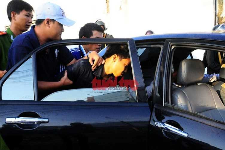 Cảnh sát đưa nghi can lên xe về cơ quan công an