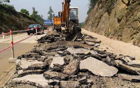  Đoạn trên đỉnh dốc Đồng Bụt bị nứt, sụt lún, nhà thầu phải dùng máy múc xới lên làm lại.