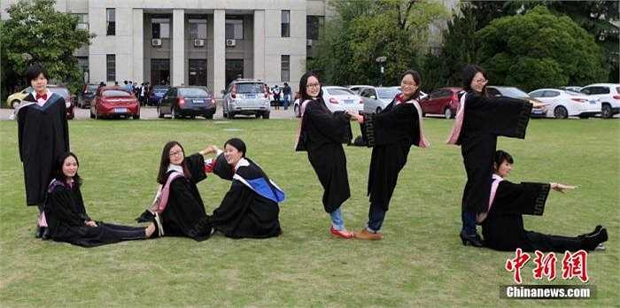 8 cô gái khác đang tạo hình trong bộ đồ tốt nghiệp của trường.