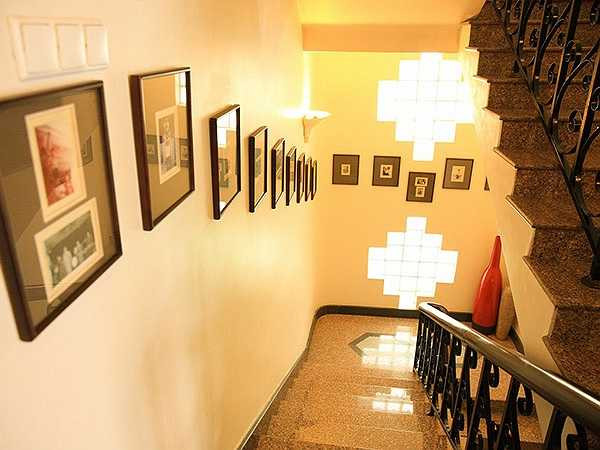 Cầu thang lên lầu 1 được trang trí với những hình ảnh kỷ niệm của Elvis Phương. 