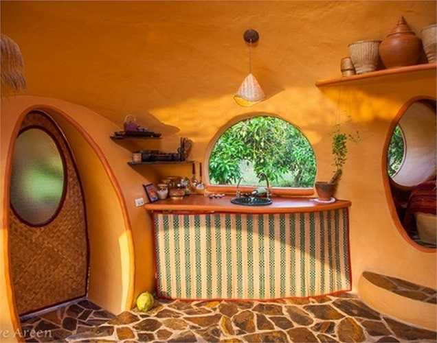 Nhà tắm nối với phòng bếp bằng cánh cửa nan tre có kính mờ.