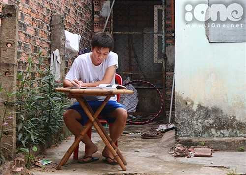 Đỗ, sinh viên khoa Công tác xã hội (ĐH KHXH&NV TPHCM), phải kê bàn học ra giữa sân để tránh cái nóng hầm hập bên trong phòng trọ xập xệ.