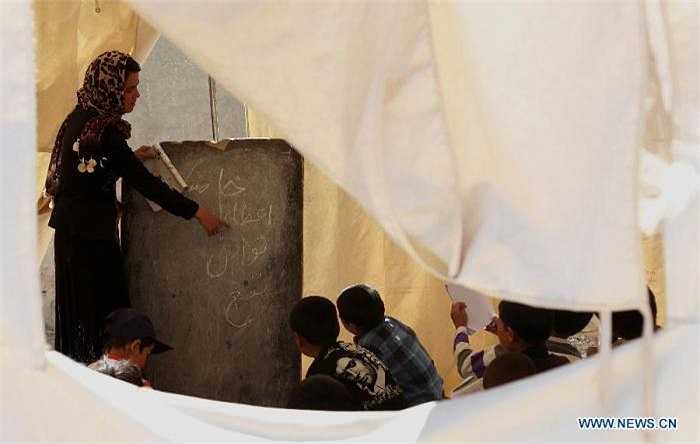 Còn đây là cảnh cô giáo đang giảng bài cho các học trò bên trong một túp lều được lập tạm bợ trong trường.