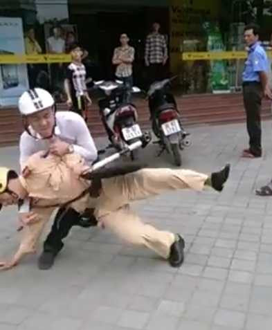  Trần Quang Độ quật ngã, hành hung thiếu úy CSGT trên phố. Ảnh: Cắt từ clip.
