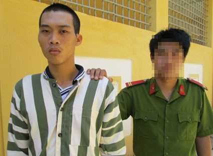 Long (trái) bị công an dẫn giải về phòng giam