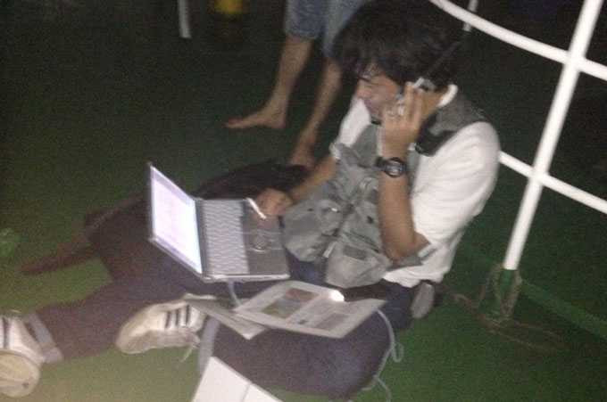 Phóng viên Yatagai Toshihiro (Hãng tin Kyodo) đang truyền hình ảnh về tòa soạn qua thiết bị vệ tinh lúc 2 giờ sáng - Ảnh: Thuận Thắng