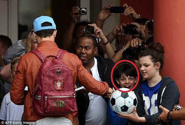 Một cậu bé phấn khích với phần quà là trái bóng có chữ kí của siêu sao người Bồ Đào Nha