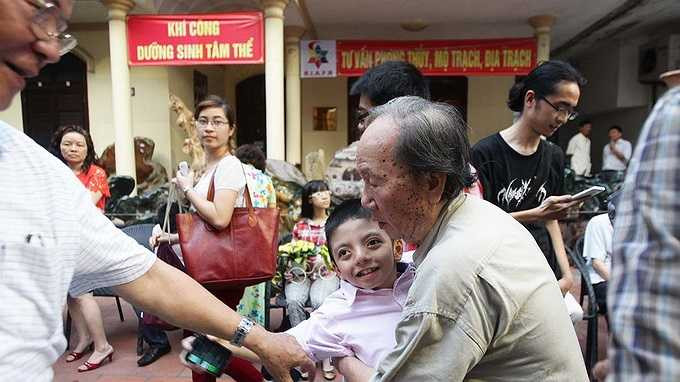 Nem trong vòng tay của ông ngoại và ông nội trong ngày khai mạc triển lãm tranh vào trung tuần tháng 5. Ông nội của Nem là giáo sư sinh học Hà Đình Đức 