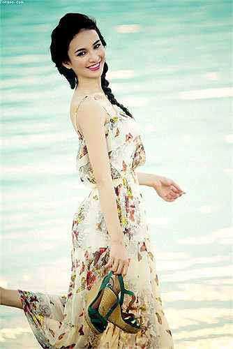 Hoa hậu du lịch Ngọc Diễm diện váy in họa tiết hoa duyên dáng khi thả bộ trên bờ biển.