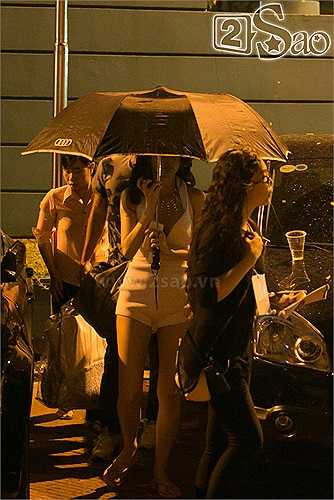 Trời mưa nên cô phải che dù đi từ chỗ đậu xe vào điểm diễn. Bà mẹ một con tóc vẫn còn đang uốn lọn, chân mang dép tông.