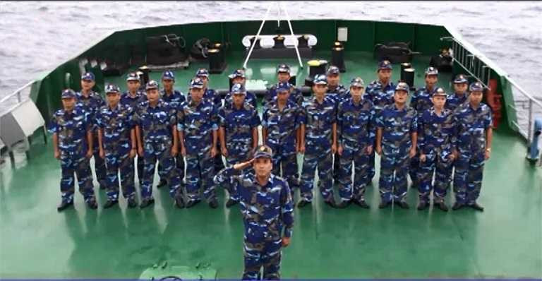 Cán bộ chiến sĩ trên tàu nghiêm trang trước lá cờ Tổ quốc. 