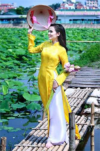 Trong bộ áo dài vàng, Diễm Hương nổi bật giữa không gian của đầm sen