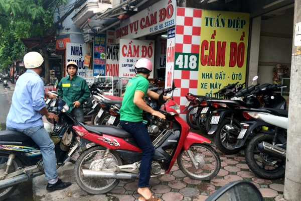 Xe máy của khách cầm cố được xếp kín trên vỉa hè trước các tiệm cầm đồ (ảnh B.H)