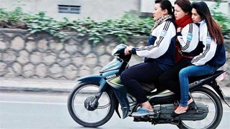 Nhiều học sinh nữ ở Hà Nội vô tư chạy xe đầu trần, chở quá số người quy định.