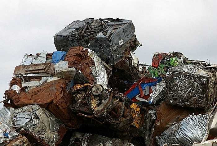 Những chiếc xe cũ được nghiền nát, đóng cục thành từng khối sắt vụn để đem đi tái chế.