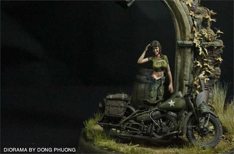 Nữ binh sĩ Mỹ đứng trước một chiếc mô tô.