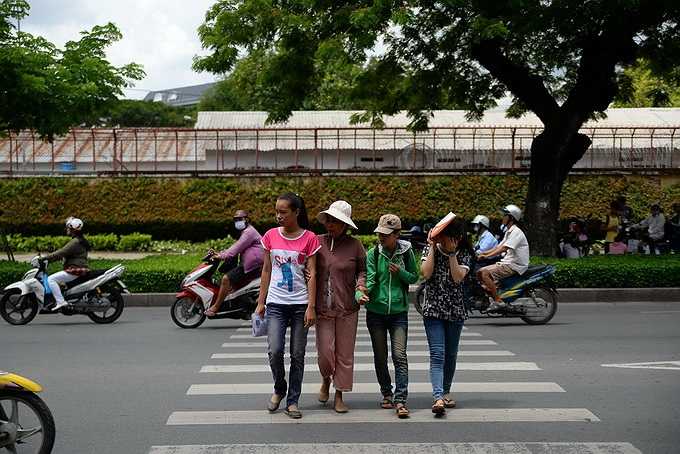 Một phụ huynh dẫn con qua đường vào phòng thi