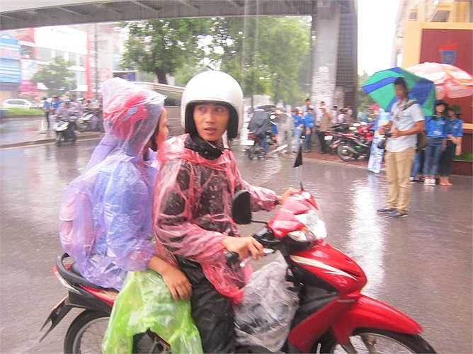 Dường như áo mưa cũng không đủ ngăn lại những hạt mưa dày hạt. Mặc tới 2 lớp áo mưa mà 2 bố con sĩ tử này vẫn ướt sũng.