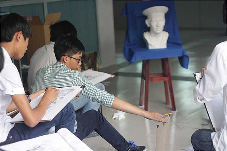  Nguyễn Trường Phú (18 tuổi, H.Cái Bè, Tiền Giang) đối chiếu lại hình vẽ của mình so với mẫu. Theo Phú, bài thi của cậu khá tốt, nhưng phần vẽ dòng chữ trên mũ lại không như ý vì quá nhiều chi tiết.