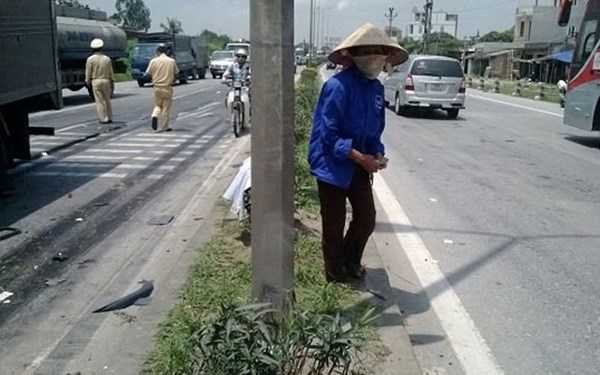 Một người dân lao ra đường nhặt tiền người qua đường ném lại hiện trường vụ tai nạn, bất chấp dòng xe cộ đông đúc.