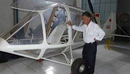  Ông Vimar Nguyễn với mái tóc bạc bên chiếc máy bay VAM 2 nằm trong kho chứa. (Ảnh TPO)