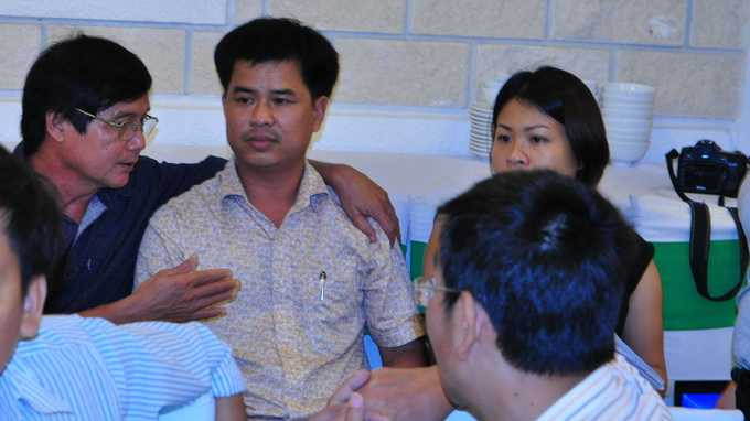 Giám đốc Sở Tài nguyên và Môi trường Quảng Nam, Nguyễn Viễn, (áo đen) ngăn ông Lê Đình Thục trong việc vào cuộc họp báo đòi nợ - Ảnh: Tấn Vũ