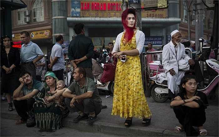 Một phụ nữ Duy Ngô Nhĩ, Tân Cương đứng chờ xe buýt