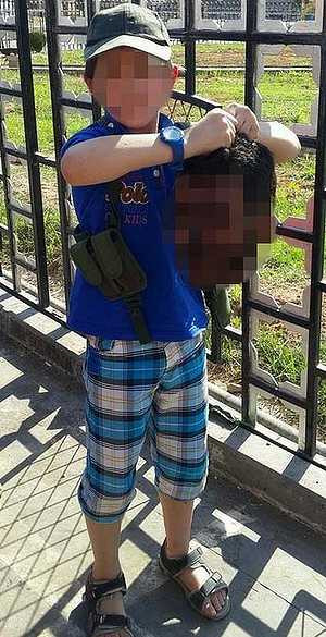 Thế giới phẫn nộ cha đăng ảnh con xách đầu lính Syria