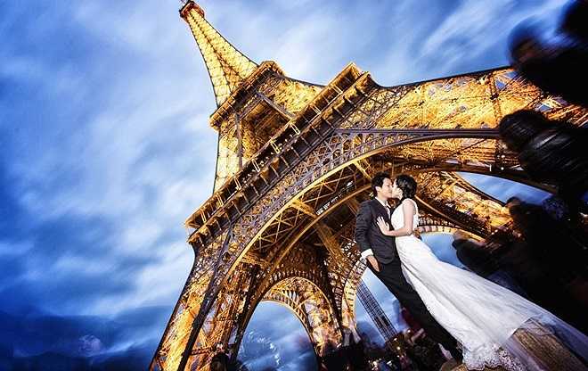 Ảnh cưới đẹp lung linh của Khánh Vy và Anh Vũ dưới chân tháp Eiffel - biểu tượng của nước Pháp. Cặp đôi Khánh Vy và Anh Vũ kết hôn vào tháng 3/2014. Nhờ phần thưởng trong một cuộc thi nên họ có cơ hội đi khắp châu Âu chụp ảnh cưới trong 30 ngày. 