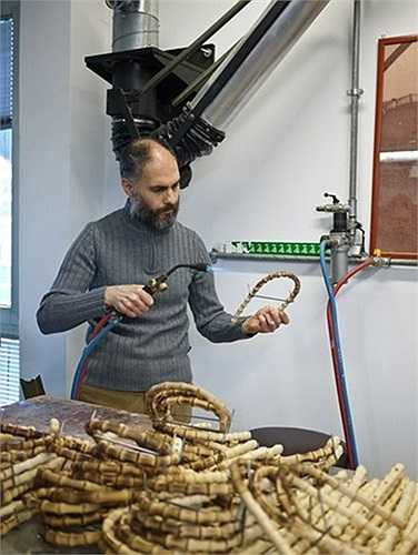 Người thợ thủ công đang chế tác những chiếc tay cầm túi xách bằng tre.