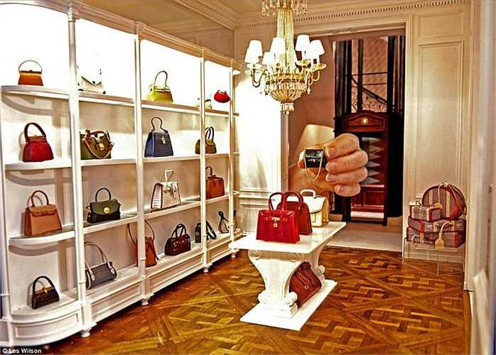 Một bức ảnh độc đáo với bàn tay thật đang cầm một chiếc túi xách hàng hiệu phiên bản mini trong tiệm bán đồ hiệu. Được biết, cặp đôi nghệ sĩ đã dành suốt 30 năm qua để sáng tạo những nhà búp bê vô cùng ấn tượng.