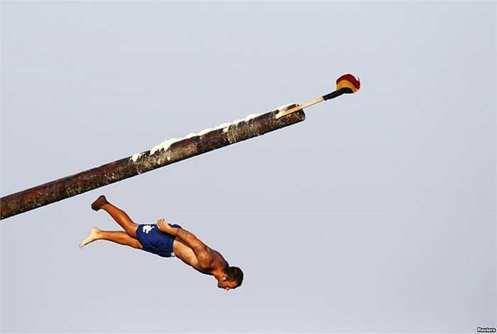 Một người đàn ông trượt khỏi cột mỡ, trong kỷ niệm lễ tôn giáo Thánh Julian kéo dài một tuần, bên ngoài Valletta, Malta