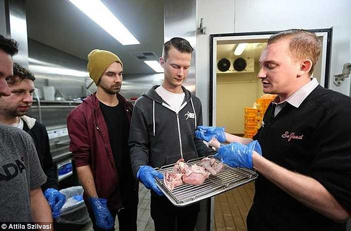 Quản lý nhà hàng Ben Sondermeyer (ngoài cùng bên phải) chỉ cho du khách thấy các nguyên liệu từ ngực, chân, đùi và cánh gà tươi được bảo quản trong từ nhiệt độ phòng mát mẻ.