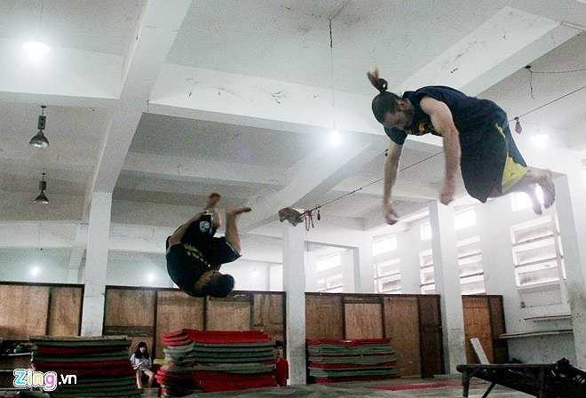 Vy Thành, người đã có 7 năm tập môn thể thao mạo hiểm này chia sẻ, các bạn trong nhóm chủ yếu tập các động tác được gọi là Tricking (dậm nhảy từ giá dây cao su bay lên lộn vòng và tiếp đất xuống đệm), Backflin (xoay người và bật nhảy từ dưới đất lên không trung), nhảy vượt địa hình và nhảy các động tác tự do. Trong ảnh, hai thành viên nhảy động tác Tricking, bay người lên cao và lộn nhiều vòng.