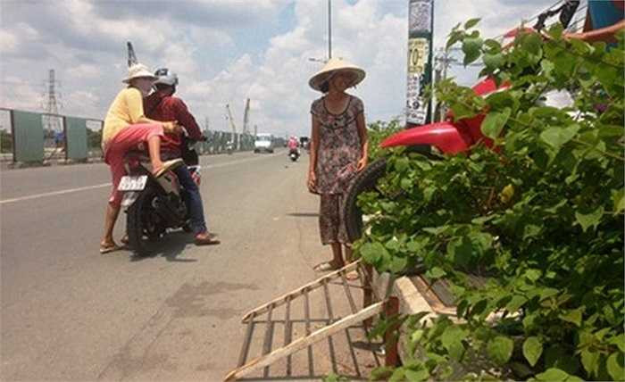 Nắm bắt được nhu cầu của người dân, tại khu vực gần hàng rào công trình bị khóa, một phụ nữ khá lớn tuổi đã mang 2 chiếc vỉ sắt làm cầu bắc ngang dải phân cách khá cao giúp phương tiện vượt qua và thu phí… 2000 đồng/lượt.