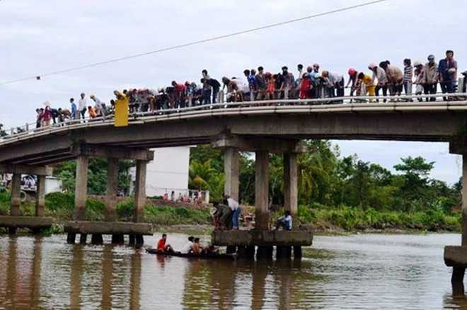 Nhiều người hợp sức kéo cái đú dính câu lên nhưng không kéo lên hết nổi.