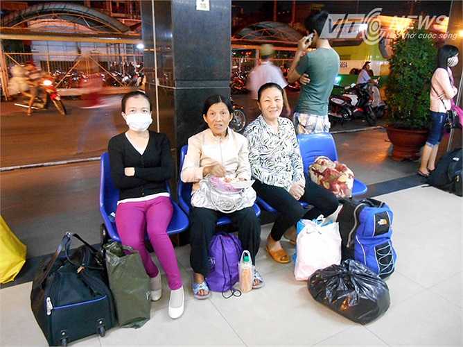 Những người này đang ngồi ăn lót dạ ở phía ngoài một khu nhà cạnh đường trong lúc chờ xe. Ảnh: Phan Cường