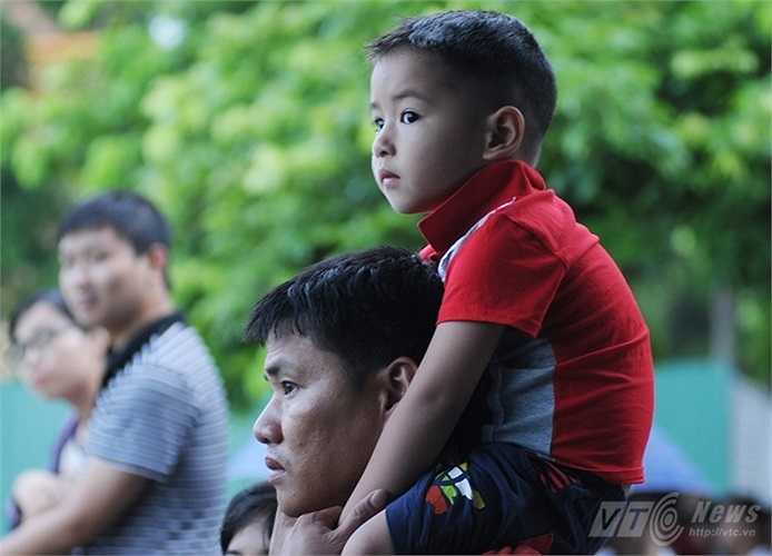 Cậu bé được bố cho lên vai để xem chào cờ rõ hơn