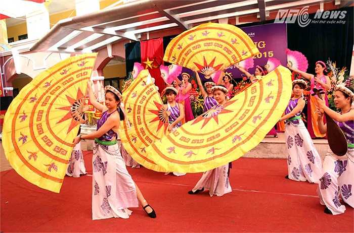 Múa quạt với hình ảnh của mặt trống đồng.