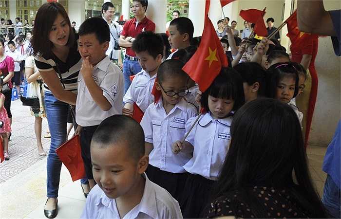 Ra sân chuẩn bị cho lễ chào cờ, nhiều học sinh còn rớm nước mắt, bố mẹ phải luôn đi bên cạnh để động viên. (Ảnh: Minh Chiến)