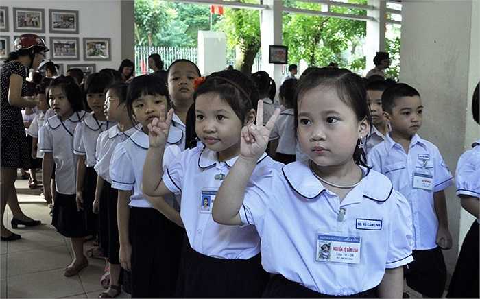 Học sinh lớp 1 tạo dáng chụp hình kỉ niệm trong ngày khai giảng. (Ảnh: Minh Chiến)