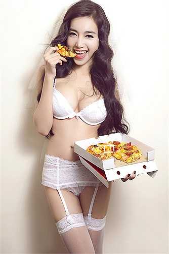 Hình ảnh Elly Trần diện nội y cô dâu và tạo dáng với bánh pizza độc lạ khiến không ít người hâm mộ ngạc nhiên. 