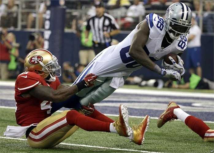 Cầu thủ của Dallas Cowboys (áo trắng) trong một pha tranh bóng với cầu thủ của đội San Francisco 49ers trong một trận bóng bầu dục NFL ở thành phố Arlington, bang Texas, Mỹ