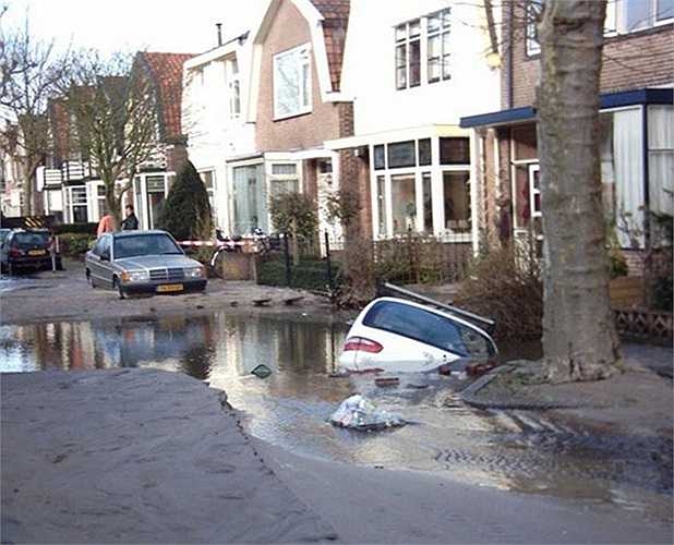 Chủ nhà và chủ xe trong ảnh này không hiểu nguyên nhân vì sao sau một đêm, trước cửa nhà thành cái ao và xe thì dưới ao.