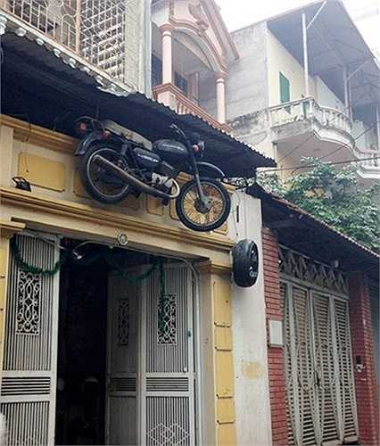 Ngôi nhà trở nên đặc biệt 'quái dị' khi chủ nhân treo cả một chiếc xe máy ở trước cửa nhà.