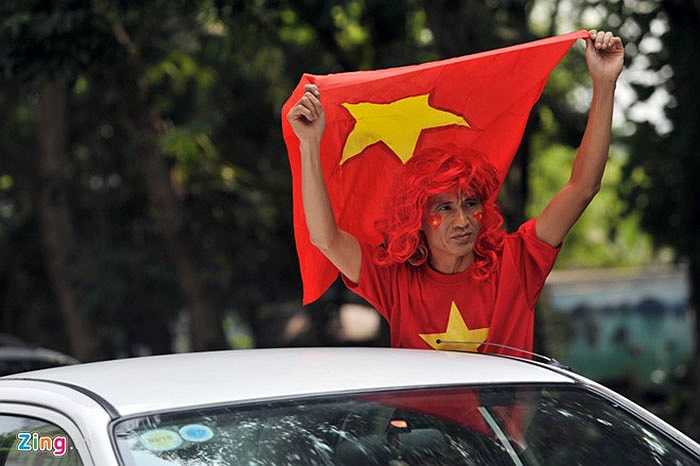 Người dân hai bên đường choáng ngợp trước rừng cổ động viên mặc áo đỏ với cờ, trống làm vang một góc phố.