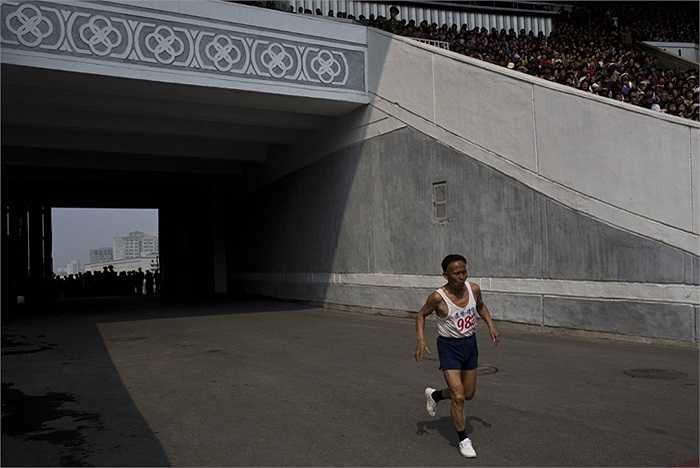 Người đàn ông đang tiến vào Sân vận động Kim Il-sung trong chặng cuối của cuộc đua