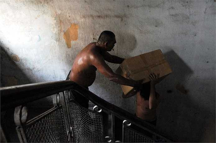 Tuy nhiên, việc vận chuyển hàng hóa để bán ở chung cư rất vất vả. Đội bốc vác phải dùng tay không vác các kiện hàng từ dưới đất lên lầu bằng cầu thang bộ. (Ảnh: Sỹ Hưng)