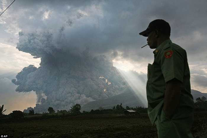 Một người đàn ông nhìn núi lửa Sinabung phun trào